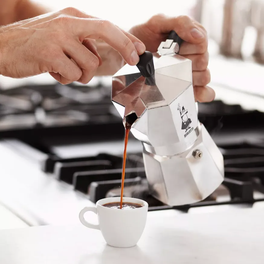 hand pouring bialetti moka pot.